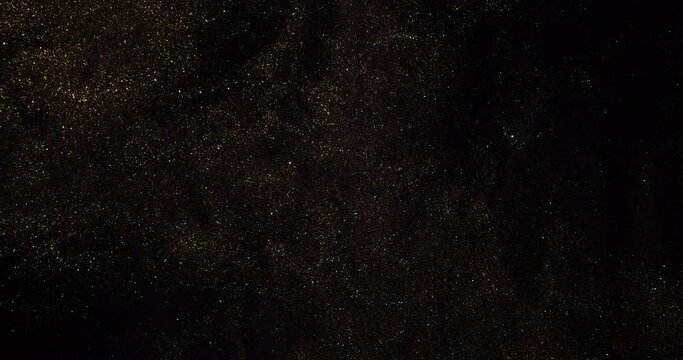 Natural moving black background with gold and silver sequins. The space of flying particles.