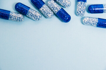 Flatlay pills on a blue paper background with copy space