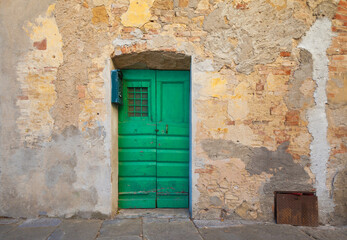 Fototapeta na wymiar old green wooden door in a Tuscany village