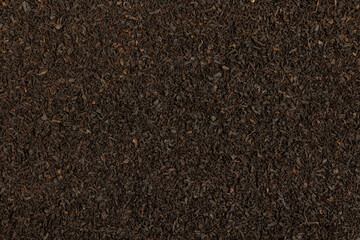 Black tea background. Dry tea brew. Tea leaf texture.