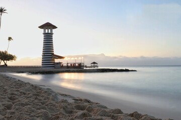 faro de luz en la costa con efecto seda en el mar © willymona