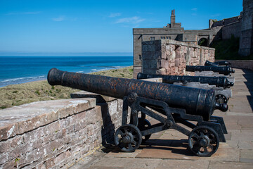 Cannons pointing out towards coast and sea, at Bamburgh Castle in Northumberland, UK