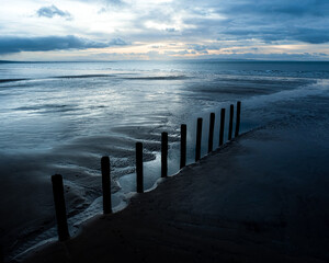 Obraz premium A line of groynes, Stevenston Beach, Saltcoats, North Ayrshire, Scotland, UK Blue