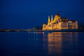 Obraz na płótnie Canvas Illuminated Hungarian Parliament building and Margit Hid, Margaret Bridge night-time view with reflection in Danube river, Budapest, Hungary.