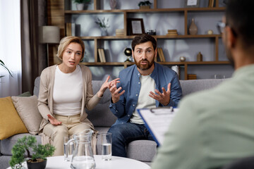 A visit to a family psychologist for a married couple. An African-American psychologist doctor consults an unhappy married couple. Relationship problems in family life. Husband and wife in a quarrel.
