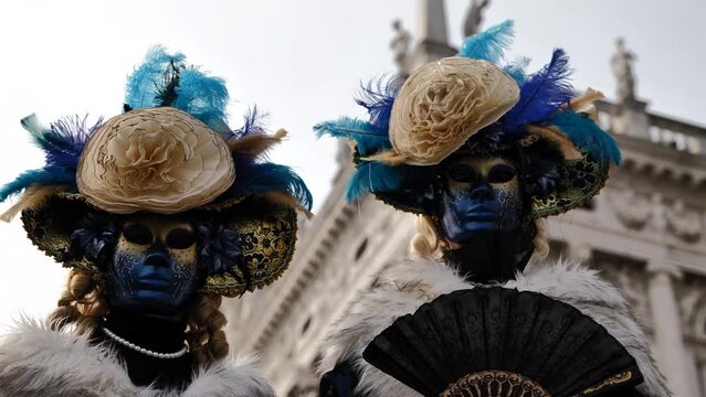 Venice - carnival masks are photographed with tourists in San Marco square