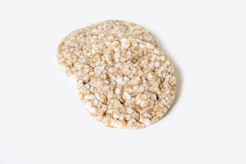 Two round rice cakes lying on top of each other on a white isolated background. Crispy rice diet product for a healthy lifestyle. Top view of rice cakes on a white background