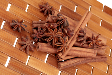 Cinnamon sticks and stars anise over wooden background