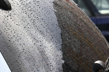 Krople deszczu - wody na karoserii samochodu i na szybie. - obrazy, fototapety, plakaty