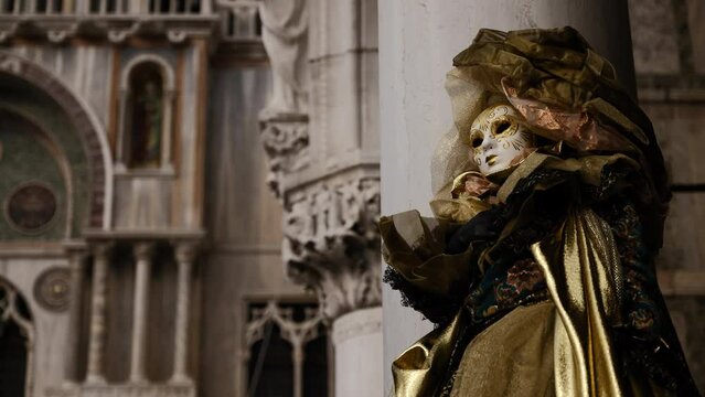 Venice - carnival masks are photographed with tourists in San Marco square