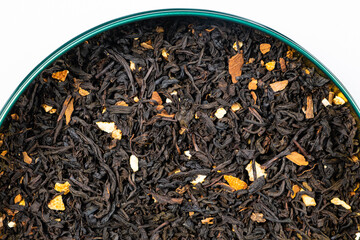 Black tea with orange peel and cinnamon close-up top view