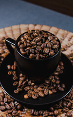 black coffee cup full of coffee beans on wooden table in dark background