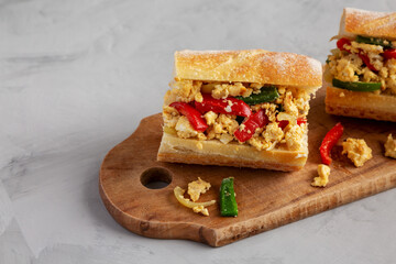 Homemade Easter Pepper and Egg Sandwich on a rustic wooden board, low angle view.