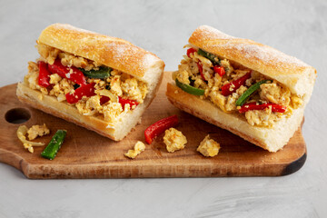 Homemade Easter Pepper and Egg Sandwich on a rustic wooden board, side view.
