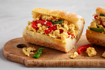 Homemade Easter Pepper and Egg Sandwich on a rustic wooden board, side view.