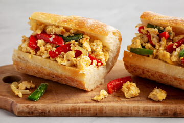 Homemade Easter Pepper and Egg Sandwich on a rustic wooden board, side view. Close-up.