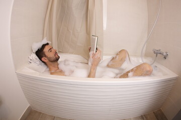 Man reading a novel in the bathtub