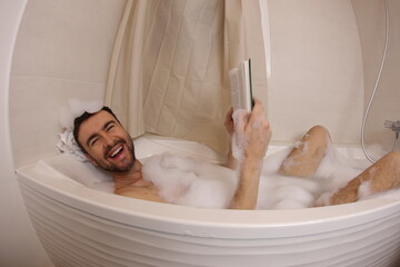 Man reading a novel in the bathtub