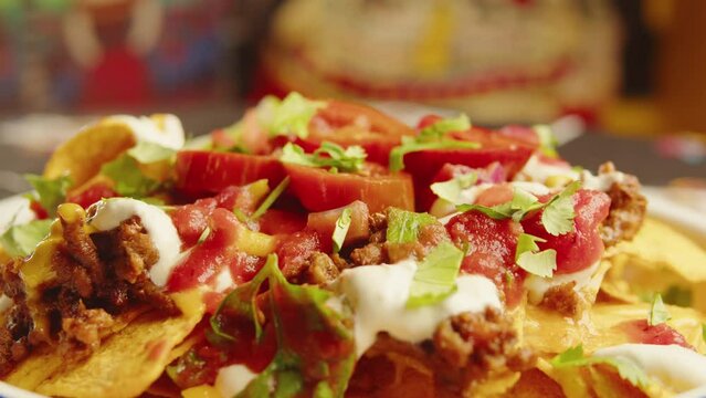 Eating Traditional Mexican food, tex mex cuisine nachos served with meat and vegetables, Taking cooked quesadilla from wooden tray, hot chilli salsa with guacamole top view.