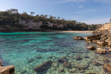 Cala Llombards. Mallorca beach.  View at water level, with clear water and the beach in the background, with a lifeguard watchtower.