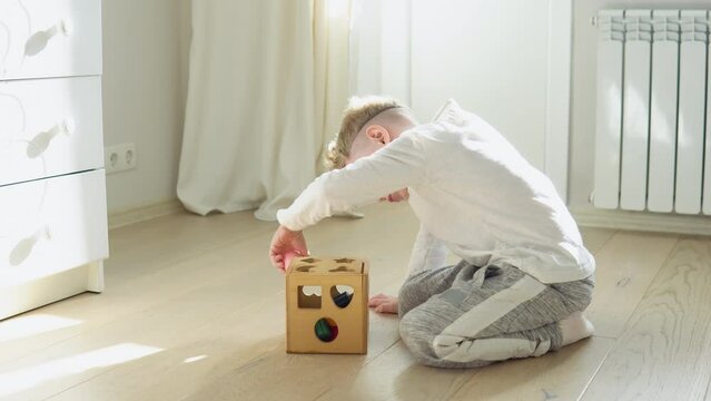 Little boy playing with wooden shape sorter