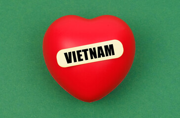 On a green surface lies a red heart with the inscription - Vietnam