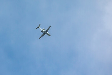 Fototapeta na wymiar A private jet plane flying in a blue sky between clouds. Transportation. Air travel. Luxury.