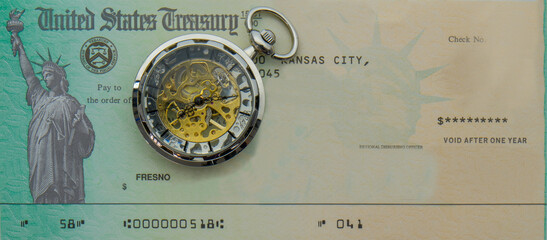 Photo of blank US Treasury check mock up with a modern pocket watch on top. Treasury check has statue of liberty image - obrazy, fototapety, plakaty