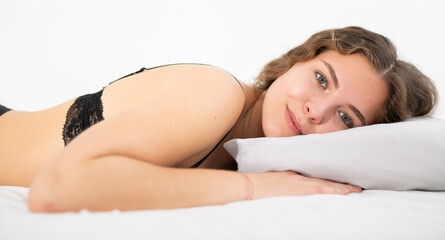 Obraz premium Young and beautiful brunette girl lying in the bed. Morning in the bedroom