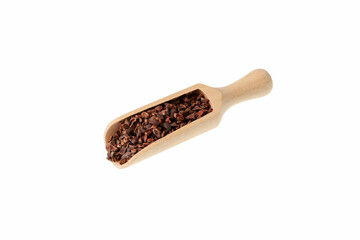 Cocoa nibs in wooden scoop. Crunchy pieces of peeled, crushed and lightly roasted cocoa beans with...