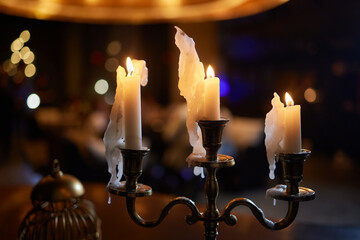 Burning candles on a table in a cozy home close-up on a table in a home interior. Evening romantic dinner at the restaurant.