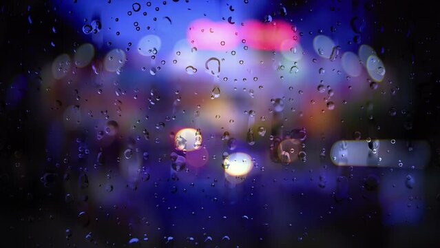 Rain running down a window against bokeh background