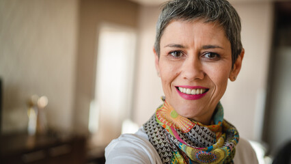 Close up portrait of one senior woman with short gray hair happy smile indoor copy space
