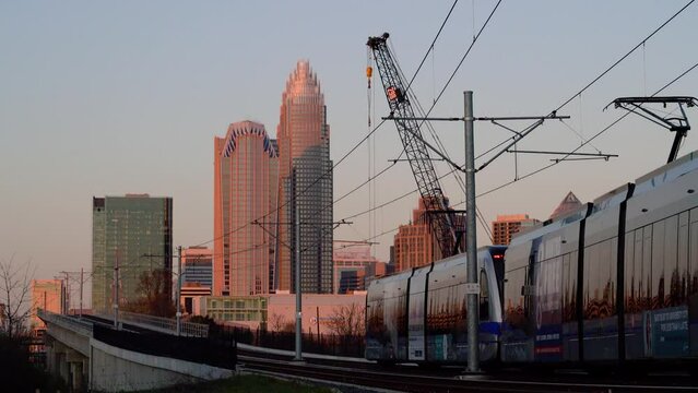 Commuter train on overpass with nearby crane near downtown Charlotte North Carolina