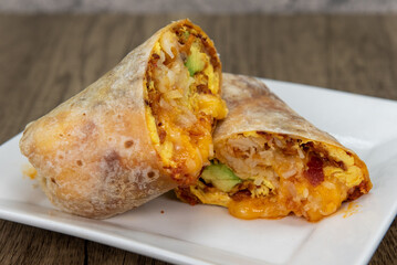 Overhead view of chorizo breakfast burrito with eggs, salsa, and cheese all wrapped in a grilled...