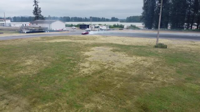 Red Drift Car / Race car drifting around corner very fast with lots of smoke from burning tires on speedway / racetrack / drift track. Infiniti g35 v8. JDM car. Luxury red sport car.