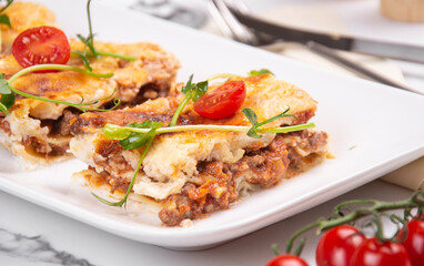 Lasagna cut into portions served on a white dish