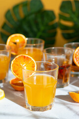 beach citrus drinks on a warm background with monstera leaves