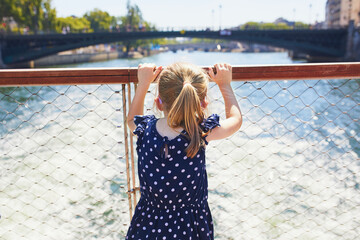 Adorable preschooler girl anjoying the view from tourist boat floating on Seine in Paris