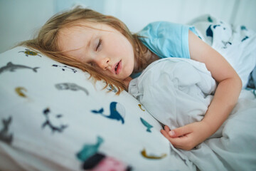 Obraz na płótnie Canvas Preschooler girl sleeping in her bed
