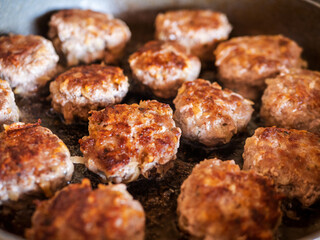 Delicious homemade meatballs frying in the frying pan