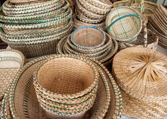 A pile of handmade traditional woven baskets made from straw, natural fiber, for sale at the outdoor market in Cuenca, Ecuador
