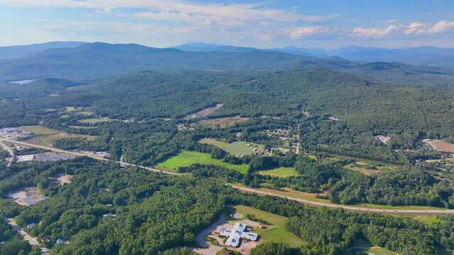 Plymouth State University and Pemigewasset River aerial view with White Mountain National Forest at the background in summer in historic town center of Plymouth, New Hampshire NH, USA. 