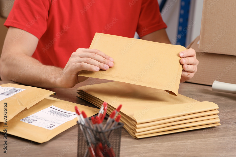 Sticker Post office worker with adhesive paper bags at counter indoors, closeup