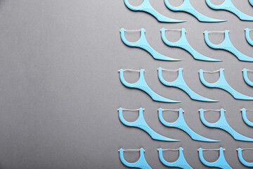 Flat lay composition with dental floss picks on grey background. Space for text