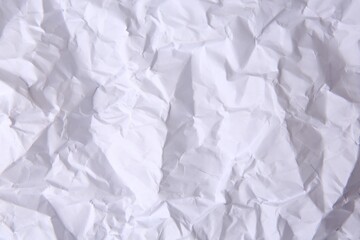 Sheet of crumpled paper white as background, top view