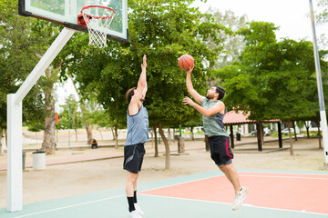 Full length of friends having fun playing basketball