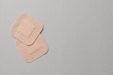 Contraceptive patches on light grey background, flat lay. Space for text