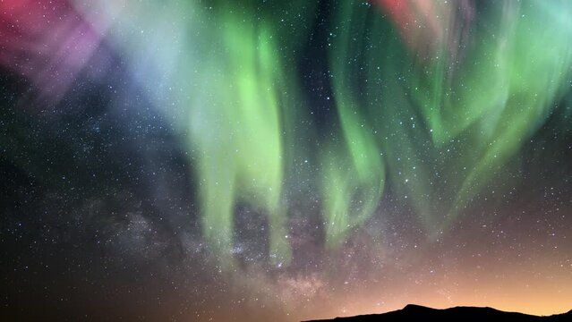 Aurora Green Purple Red and Milky Way Galaxy Over Horizon Tilt Up