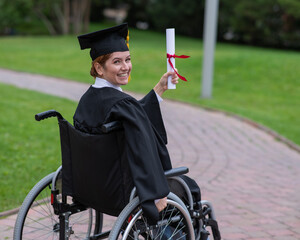 Happy caucasian woman in a wheelchair turns around and holds her diploma outdoors.